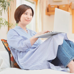 リビングでパソコン作業する女性