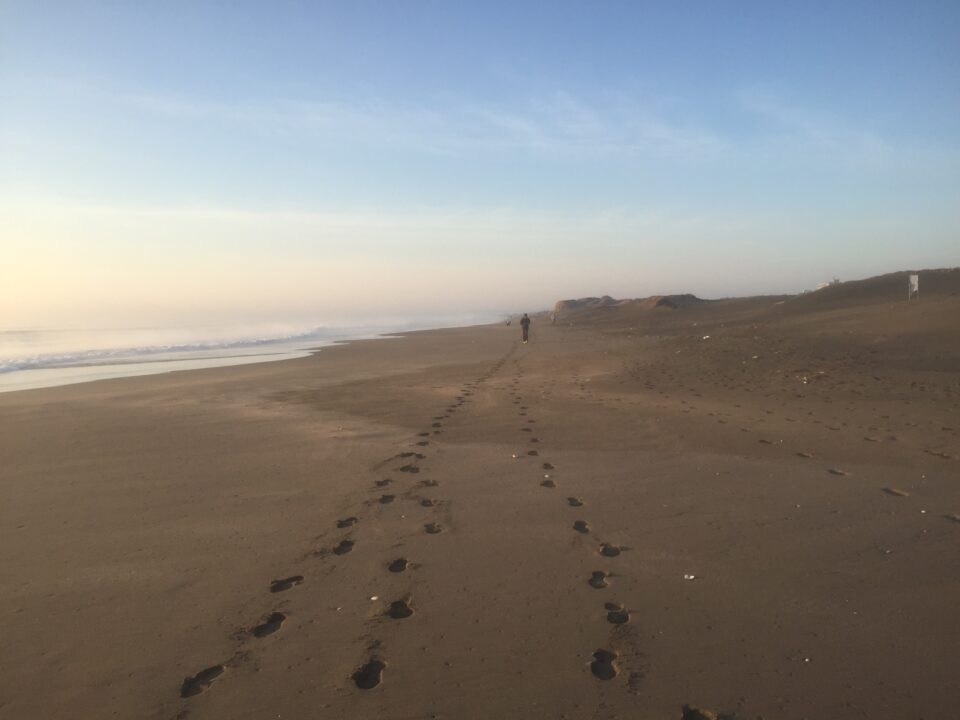 朝の砂浜のジョギング風景